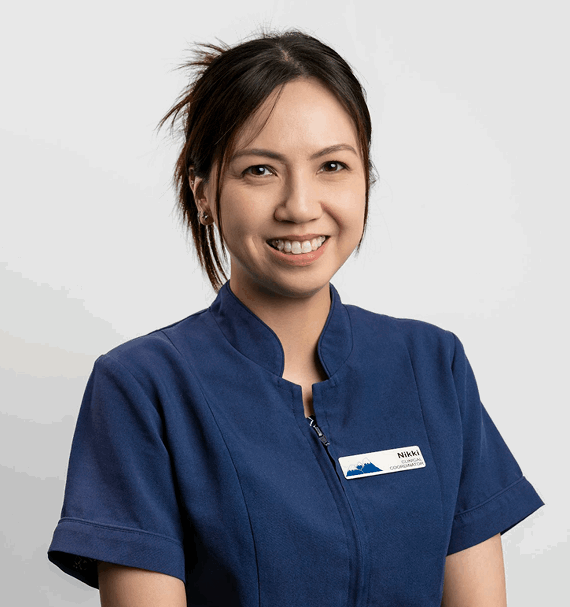 Portrait of Nikki Tran, Dental Assistant, smiling in navy uniform