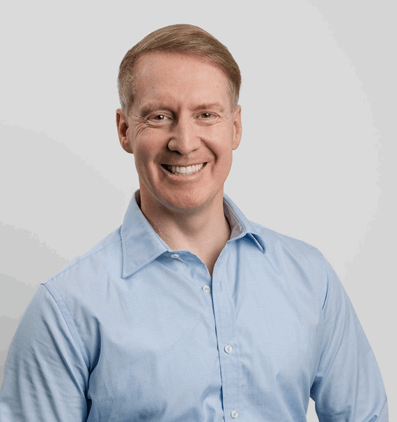 Portrait of Mark Davie, Practice Manager, smiling in light blue shirt