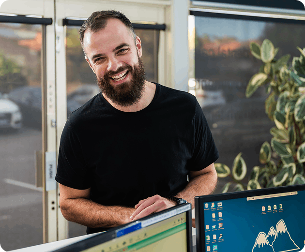 Confident man smiling outdoors while holding a coffee cup after dental treatment