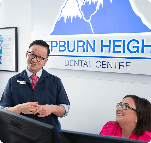 Smiling dentist talking to a young patient in the waiting area
