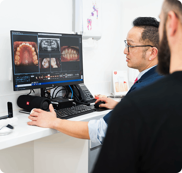 Dentist explaining X-ray results to a patient seated in the clinic